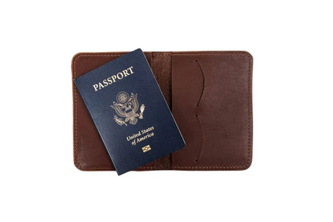 A blue U.S. passport is partially tucked into an open brown Urban Southern Passport Wallet, displayed on a white background.