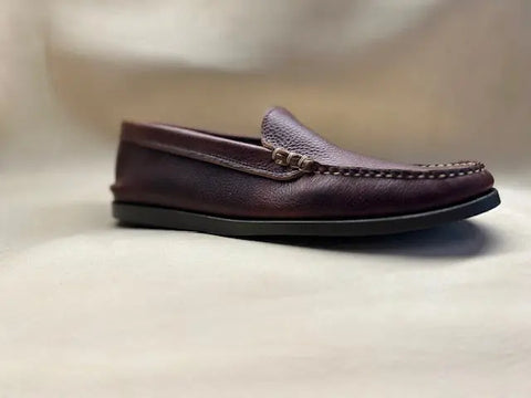 The BBH Loafer features brown pebble grain leather, visible stitching, and a beaded accent on the upper, displayed against a softly blurred neutral background.
