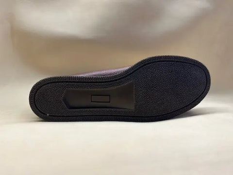 A close-up of the sole of the BBH Loafer highlights its brown textured rubber tread with a central rectangular detail, capturing classic American shoemaking against a light background.