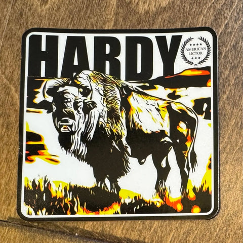 Sticker: Bison - Hardy by American Lictor is a 3 x 3 sticker featuring a stylized bison, HARDY in bold above, and the American Lictor emblem. The design uses black, white, orange, and yellow for a striking fiery look.
