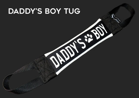 The Daddys Boy Fire Hose Training Tug by Bulletproof Pet Products Inc is a durable, black and white USA-made dog toy with DADDYS BOY (paw print for the O) and handle loops at each end.
