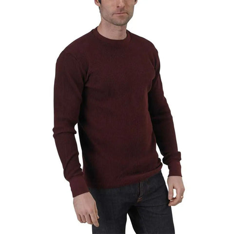A man in a dark maroon Long Sleeve Crewneck Heavy Thermal by Spiritex | Sustainable Apparel and dark jeans stands against a white background, face partially visible and hands relaxed at his sides.