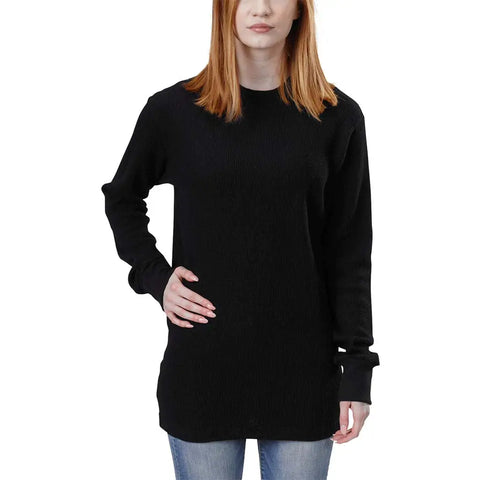 A woman with shoulder-length red hair wears a black Spiritex | Sustainable Apparel Long Sleeve Crewneck Heavy Thermal and blue jeans, standing against a white background with one hand on her hip.