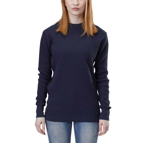 A woman with straight, shoulder-length red hair wears the Spiritex | Sustainable Apparel Long Sleeve Crewneck Heavy Thermal in dark navy and blue jeans, standing against a white background with her arms relaxed at her sides. Her face is partially visible.