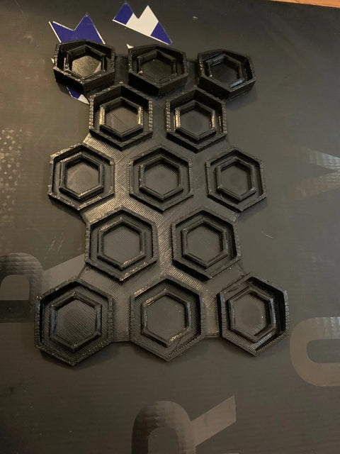 The Chatelet Manufacturing Snowboard Stomp Pad features a hexagon pattern with 3D-printed black rings in a staggered grid. Gaps highlight its modern design and durable, weatherproof adhesion for better grip on your snowboard.