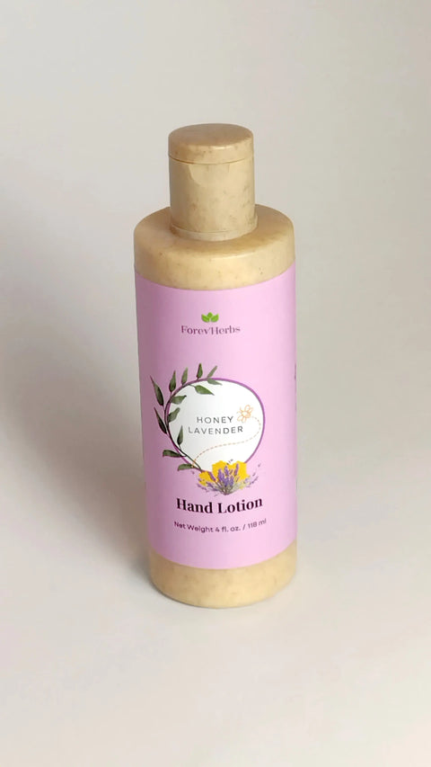 A bottle of Forev'Herbs Honey Lavender Hand Lotion with a purple label, floral design, and yellow flowers on white—a nourishing lotion for gentle daily care.