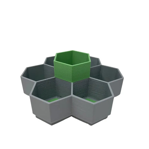 The Chatelet Honeycomb Seed Starter Tray Set by Chatelet Manufacturing features a self-watering, reusable hexagonal tray with six outer germination compartments and a central green compartment for starting vegetables, flowers, or microgreens. Made in the USA.