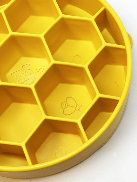 The SodaPup Honeycomb Design EBowl Enrichment Slow Feeder Bowl for Dogs features yellow silicone with hexagonal compartments and bee and honeycomb embossing—ideal for slowing your dog’s eating and promoting enrichment.