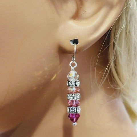 A close-up of an ear wearing Alexa Martha Designs’ Hot Pink Ombre Stacked Crystal Sterling Silver Earrings, featuring alternating faceted pink and clear beads with silver rhinestone spacers on a heart-shaped stud.