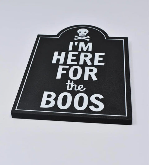 The Chatelet Manufacturing Im Here for the Boos Halloween Bar Sign Decor, made in the USA, features a black tombstone shape with a white skull and crossbones—perfect as a Halloween party decoration.