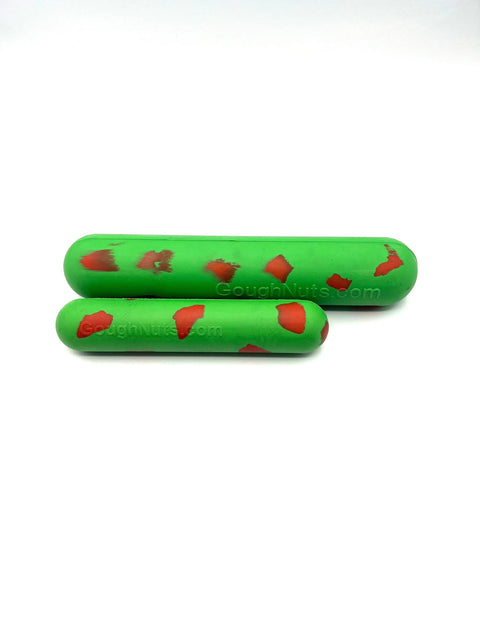 Two Goughnuts Green Stick chew toys—a large and a small—rest on a white background. These durable, green cylindrical toys with red patches come with the Goughnuts Guarantee for lasting play.