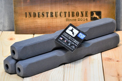 Three gray Indestructibone™ Professional Grade Mega Max Chew Toys (3 Pack) by Bulletproof Pet Products Inc, for dogs 51-100 lbs, rest on wood with a branded sign—ideal indestructible chew toys for powerful chewers.