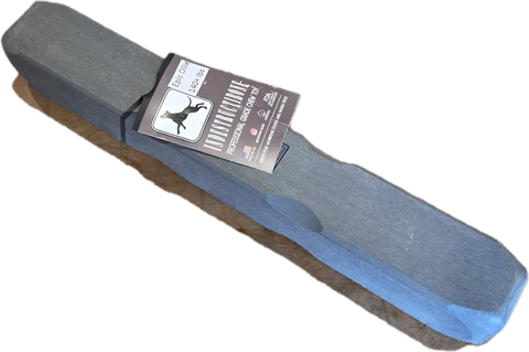 A rectangular gray block labeled with a dog silhouette and Bulletproof Pet Products Inc branding, reading Indestructibone Professional Epic Ollie Solid for Dogs 140lbs+, ideal for powerful chewers after playtime.