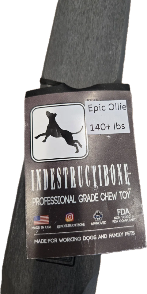 A tag for Bulletproof Pet Products Inc’s Indestructibone Professional Epic Ollie Solid for Dogs 140lbs+, featuring a jumping dog silhouette, US flag, FDA symbols, and text noting its perfect for power chewers.
