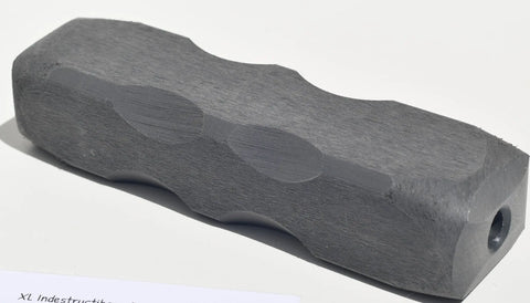 The Indestructibone™ Professional Grade XL by Bulletproof Pet Products Inc is a solid gray hexagonal dog toy for 30-50 lb dogs, featuring beveled edges, concave curves, and a hole at one end, shown on a white surface.