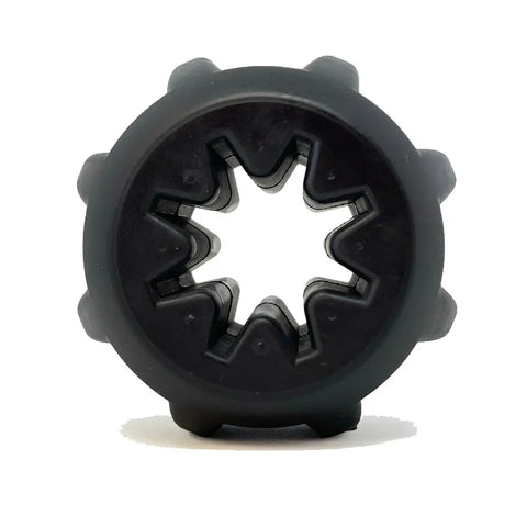 The SodaPup Gear EDispener is a black, round, durable rubber treat holder and chew toy for power chewers, featuring a star-shaped center hole and small nubs along the edge, shown upright on a white background.