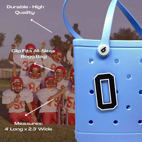A blue Bogg Bag with a Chatelet Manufacturing BOGLETS Jersey Sports Uniform T-Shirt Number charm featuring a black-and-white letter O is shown in front, while youth football players in red uniforms pose with their trophy behind.