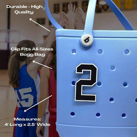 Close-up of a light blue Bogg Bag featuring a Chatelet Manufacturing BOGLETS Jersey Sports Uniform T-Shirt Number bag charm—a black-and-white number 2. Great for personalizing tote bags and as a sporty accessory for basketball fans!.