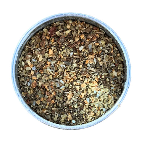 A round metal container of Gustus Vitae Kid’s Menu: Italian Pasta & Pizza Seasoning, a blend of dried herbs and spices, seen from above on a white background.