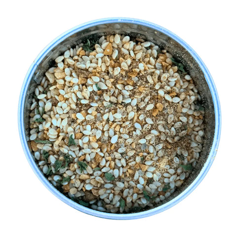 A round container of Gustus Vitae Kid’s Menu: Veggie: All Purpose Seasoning, featuring a mix of non-GMO white sesame seeds, dried herbs, and spices, shown from above on a white background.