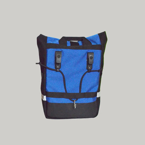 The Lone Peak Packs Kings Peak Waterproof Pannier is a blue and black backpack featuring two black clips, top handle, adjustable pannier hooks, and a reflective strip near the bottom, shown against a plain light background.