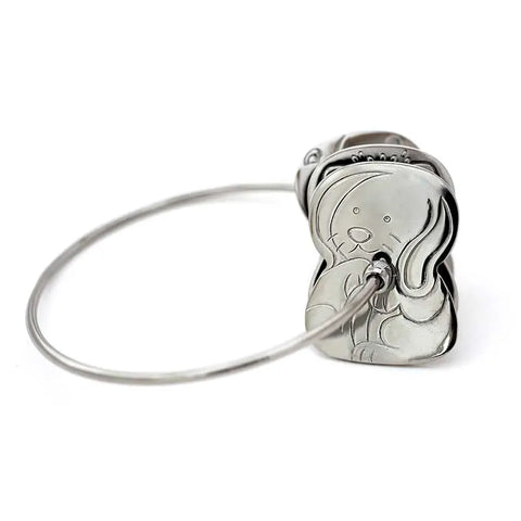 The Kleynimals Stainless Steel Rattle by Kleynimals is a silver metal keychain with a cartoon dog charm, engraved details, and a simple wire loop—a fun, eco-friendly baby gift perfect for any occasion.