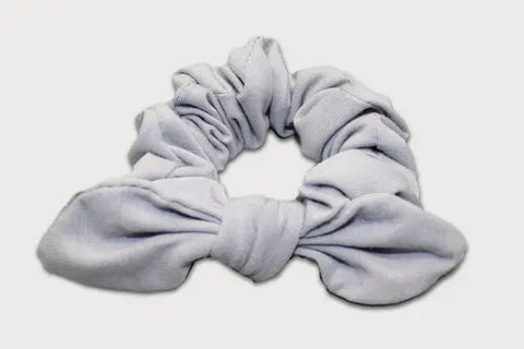 A light gray Knotted Bow Scrunchie by Goodnighties, crafted from thermoregulating fabric, displayed on a white background.