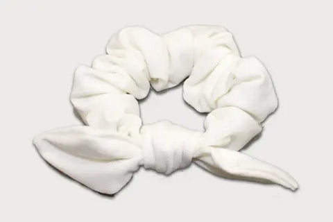 A white Knotted Bow Scrunchie by Goodnighties, made from thermoregulating fabric, is shown on a plain light background.