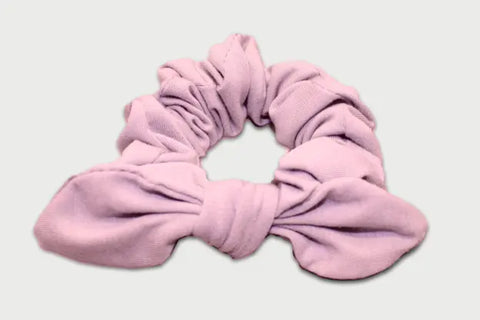 The Goodnighties Knotted Bow Scrunchie, in lavender and crafted from thermoregulating fabric, is an American-made hair accessory shown against a light background.