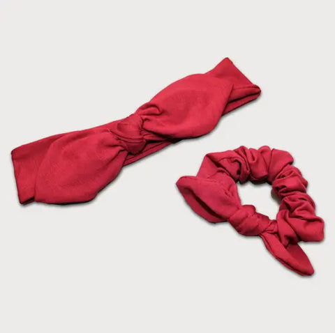 The Goodnighties Matching Knotted Bow Headband & Scrunchie set features stylish red fabric hair accessories, including a headband and scrunchie, beautifully displayed on a plain light background.