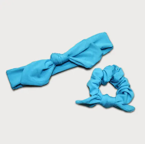 The Goodnighties Matching Knotted Bow Headband & Scrunchie set in blue adds a vibrant touch to your hair accessories collection, shown on a plain white background.
