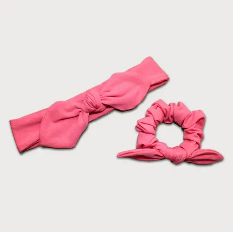 The Goodnighties Matching Knotted Bow Headband & Scrunchie set, featuring charming pink hair accessories, is displayed on a white background.