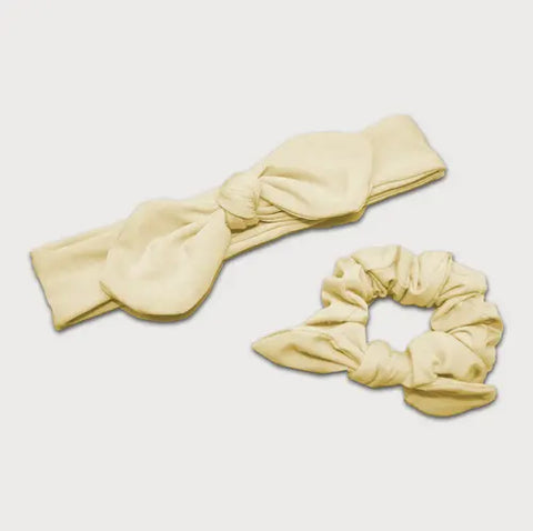 The Goodnighties Matching Knotted Bow Headband & Scrunchie set in pale yellow features chic hair accessories, shown against a plain white background.