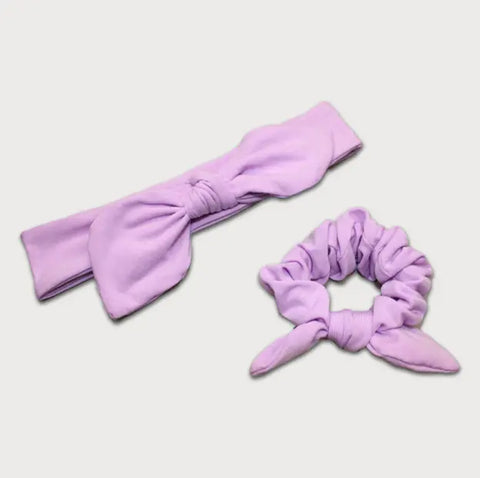 The Goodnighties Matching Knotted Bow Headband & Scrunchie set features a lavender scrunchie with cute bow accents, all displayed on a white background—stylish hair accessories for any occasion.