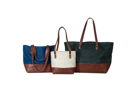 Urban Southern’s Large Canvas Tote is available in navy blue, cream, and dark green, each with full-grain leather accents on the handles and base. Crafted in America, these stylish totes add a modern touch to any look.