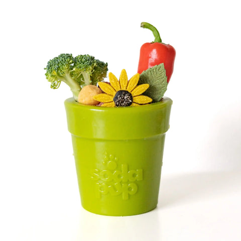 The SodaPup Large Flower Pot Durable PUP-X Rubber ECup Treat Dispenser & Enrichment Toy, shaped like a green cup, holds toy vegetables and a yellow flower for colorful dog enrichment play.