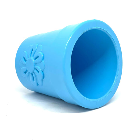 A large, light blue SodaPup Flower Pot ECup Treat Dispenser & Enrichment Toy, made from durable PUP-X rubber with a raised flower design, lies on its side against a white background—ideal for creative dog enrichment.