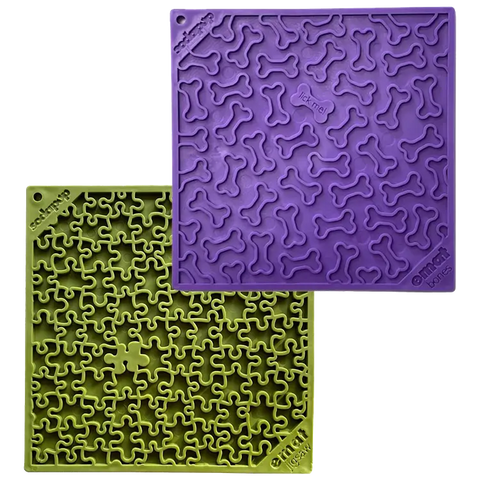 The SodaPup Large Green Jigsaw & Large Purple Bones EMat Lick Mat Bundle includes two silicone slow feeder mats with raised patterns—one green with a jigsaw design, one purple with bone shapes—for dog enrichment.
