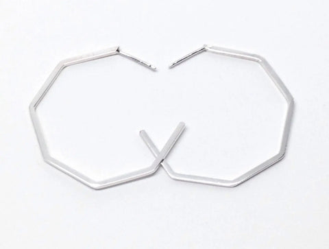 The SILVER GEO HOOPS | LARGE by Sarah Cecelia are octagonal sterling silver earrings arranged with openings facing each other on a white background—ideal for minimalist jewelry lovers.