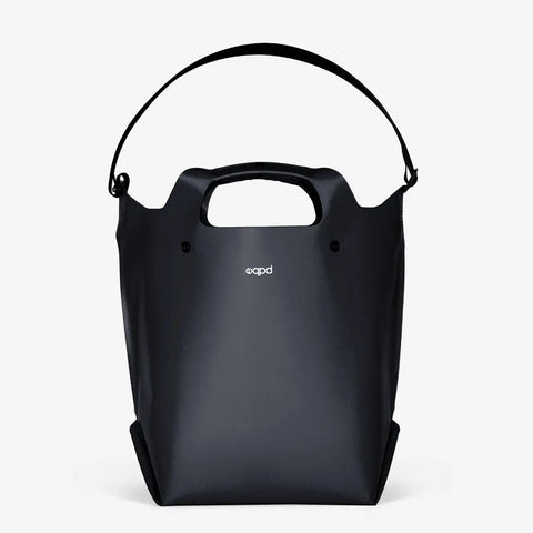 The LastBag - Shoulder by eqpd is a sleek black tote featuring a smooth finish, built-in handle, adjustable shoulder strap, and a small white eqpd logo—designed for everyday use and photographed on a plain white background.