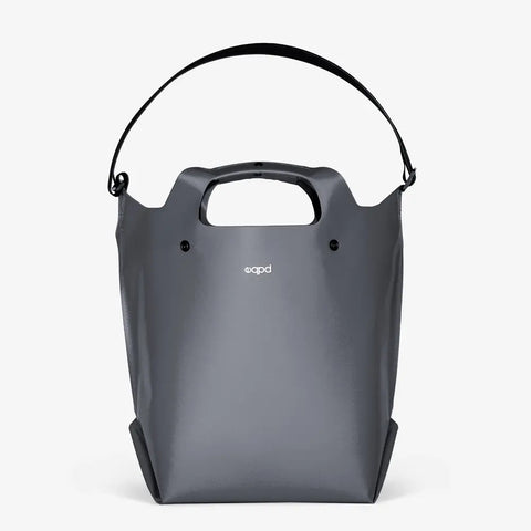 The eqpd LastBag - Shoulder is a gray, modern tote with a built-in handle, adjustable strap, and small white front logo. Minimalist and durable, this everyday bag is shown against a plain white background.