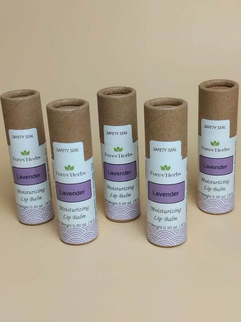 Five tubes of Forev'Herbs Lavender Lip Balm with brown cardboard caps and white-purple labels stand upright in a row against a plain background.