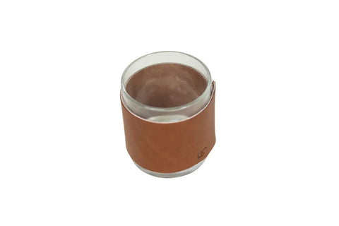 The Urban Southern Leather Wrapped Whiskey Glass features a clear tumbler wrapped in light brown full-grain leather, shown on a white background.
