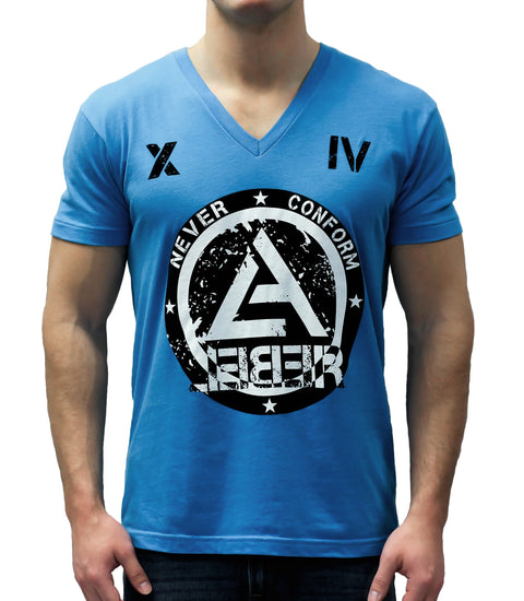 A man wears The Original blue V-neck T-shirt by Leber Apparel Line, featuring black Roman numerals X and IV on the shoulders and a large distressed white graphic reading NEVER CONFORM and AEER on the chest.