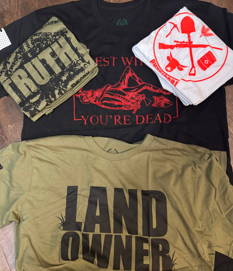 Four graphic tees from American Lictor’s T-Shirt: Legacy Design Discount Bin—a green LAND OWNER, black TRUTH, black REST WHEN YOURE DEAD, and a white with red tools and tents—could be your next surprise shirt!.