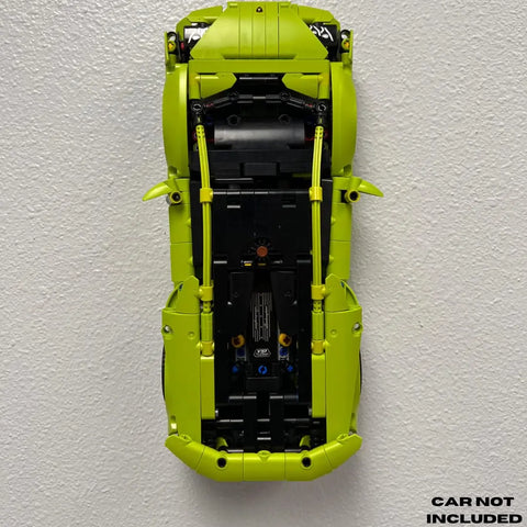 A lime green LEGO car, like the Lego Technic Lamborghini Huracán Tecnica 42161, is vertically displayed on a Chatelet Manufacturing Collectible Car Wall Mount. CAR NOT INCLUDED appears in the lower right corner.