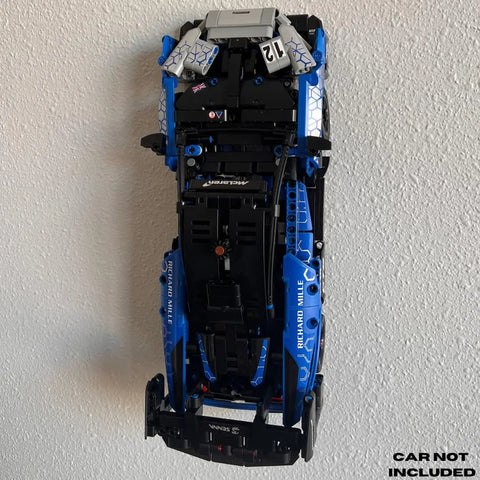 A Chatelet Manufacturing Collectible Car Wall Mount, compatible with Lego Technic Lamborghini Huracán Tecnica 42161, is mounted vertically on a white wall. CAR NOT INCLUDED is written in black text at the bottom right corner.
