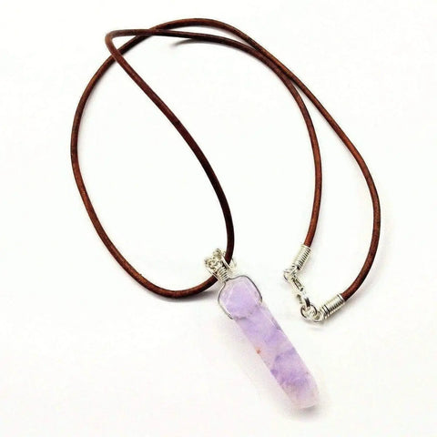 The Alexa Martha Designs Silver Wrapped Light Amethyst Gemstone Point Leather Necklace features a brown leather cord, a sterling silver wire-wrapped amethyst pendant, and a secure metal clasp.