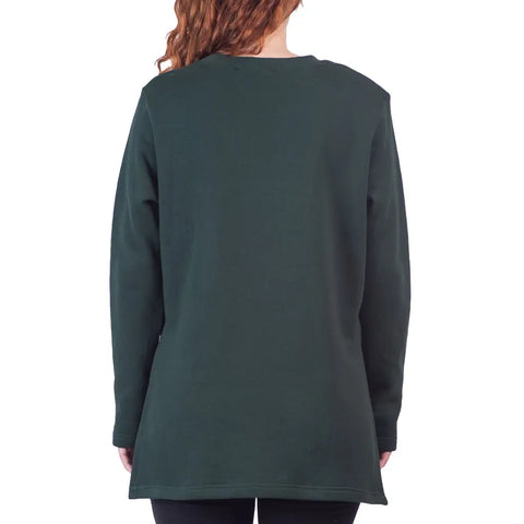 A person with wavy red hair is shown from the back, wearing the Spiritex Flint Street Fleece Pullover in dark green organic cotton and black pants, set against a white background.