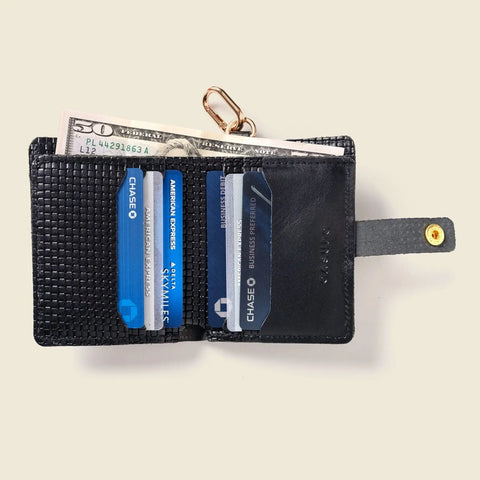 The CASUPO Wallet With Snap and Key Ring - Black Limited Edition opens to reveal cash, blue and gray credit cards, and a gold keyring inside. It features a gray strap and is secured with a gold snap button.